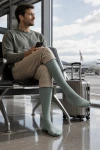 Sigvaris Traveno Reisesocken in grün am Flughafen Zürich, Mann